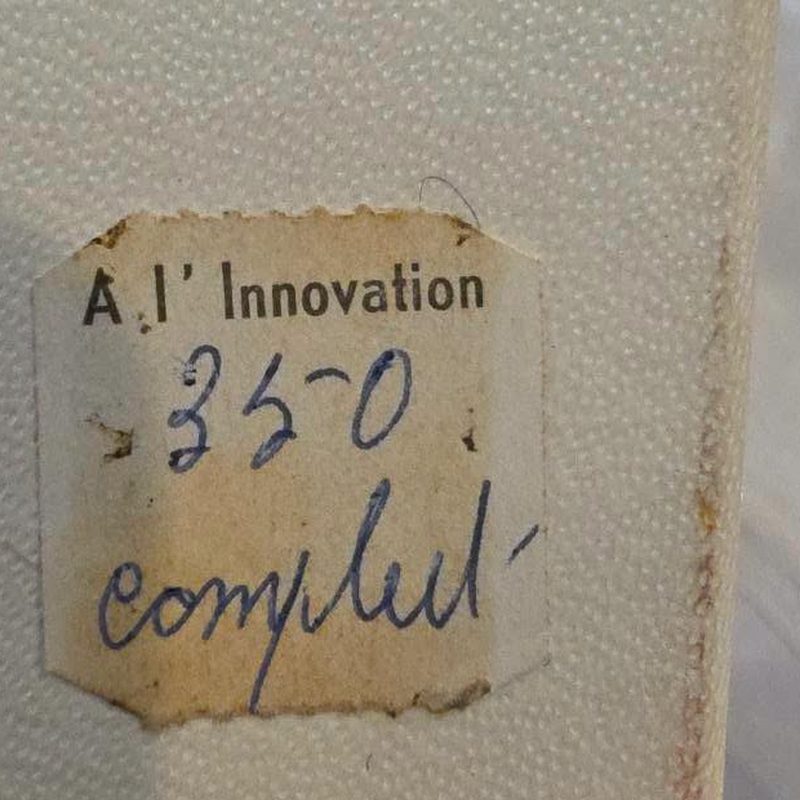 Oud prijsetiket van warenhuis A l'Innovation op een doos in de kringloopwinkel