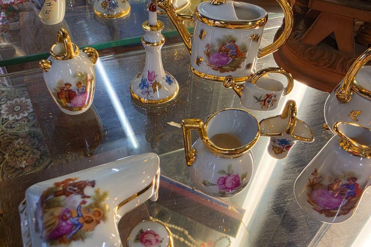 Wat is vintage: porseleinen theeservies met gouden randen in de vitrine van de kringloopwinkel